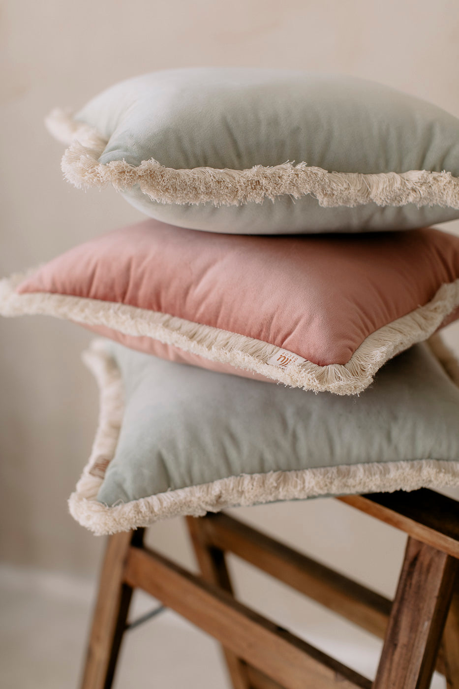set of pastel cushions on a wooden bench