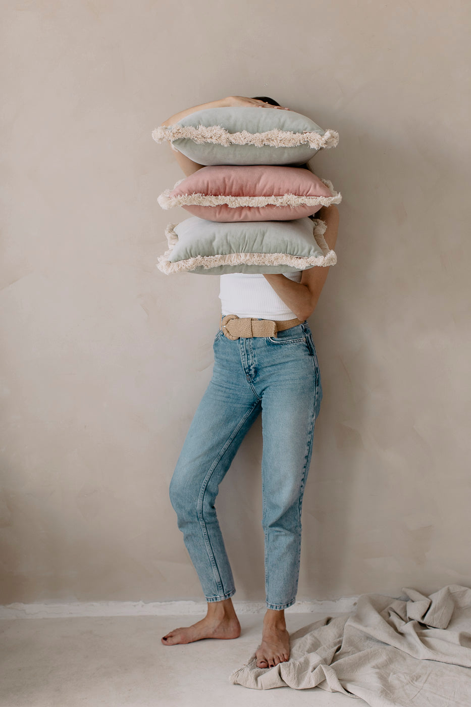 a girl holding pastel pillows