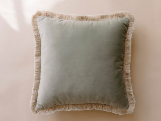 square pale green pillow with a fringe
