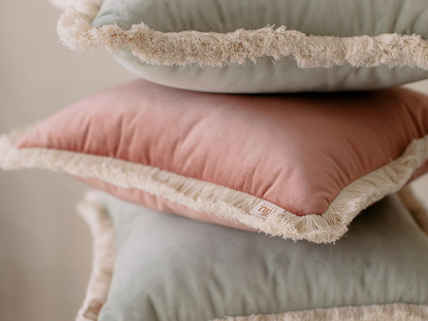 set of pastel decorative pillows with cotton fringe