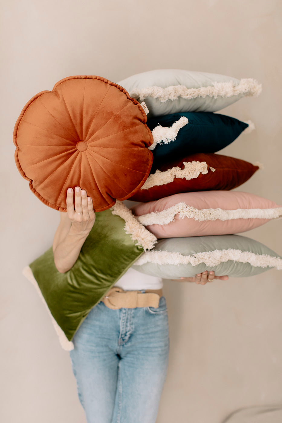 a girl holding velvet pillows