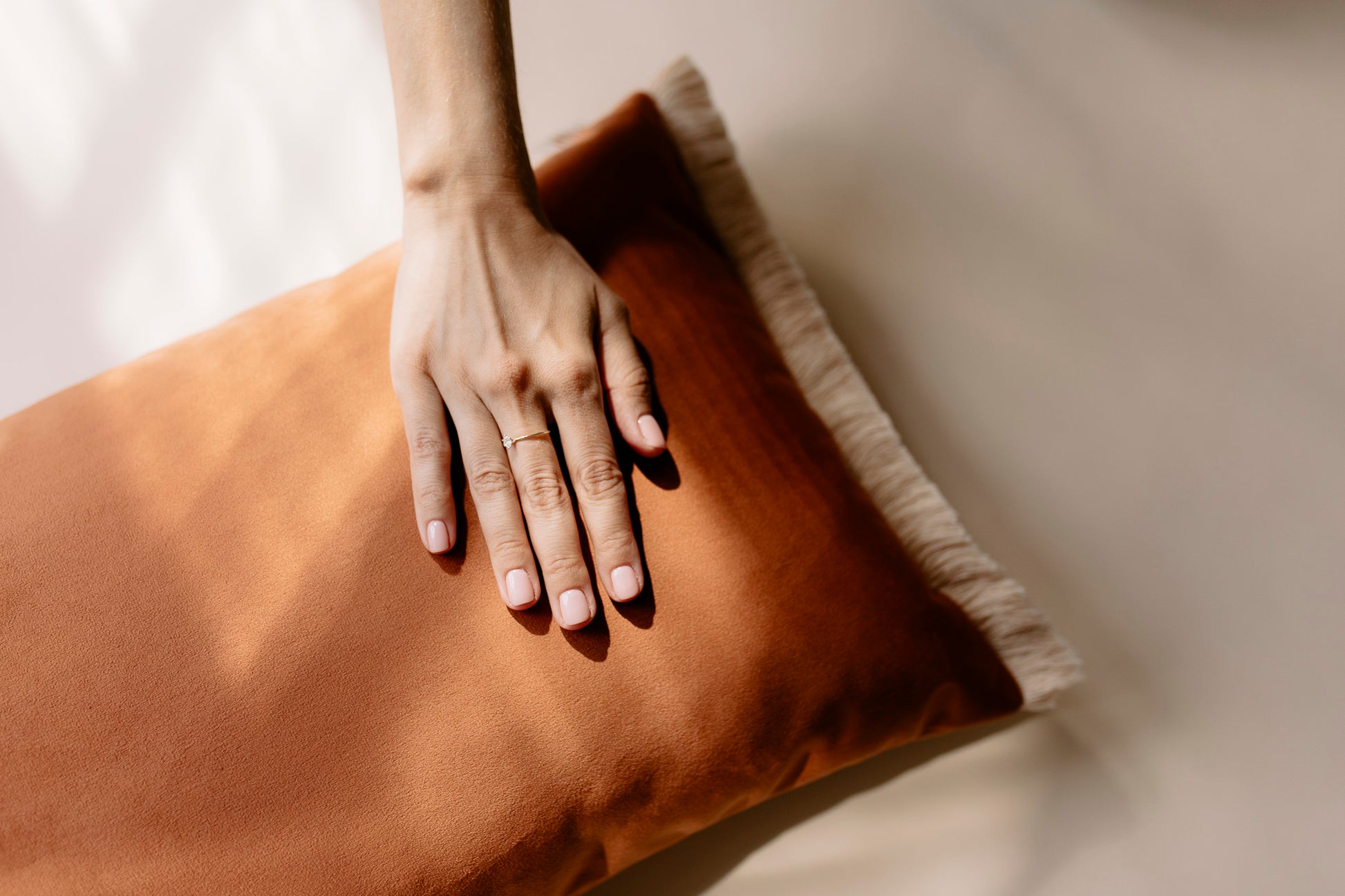 hand on a velvet rectangular cushion