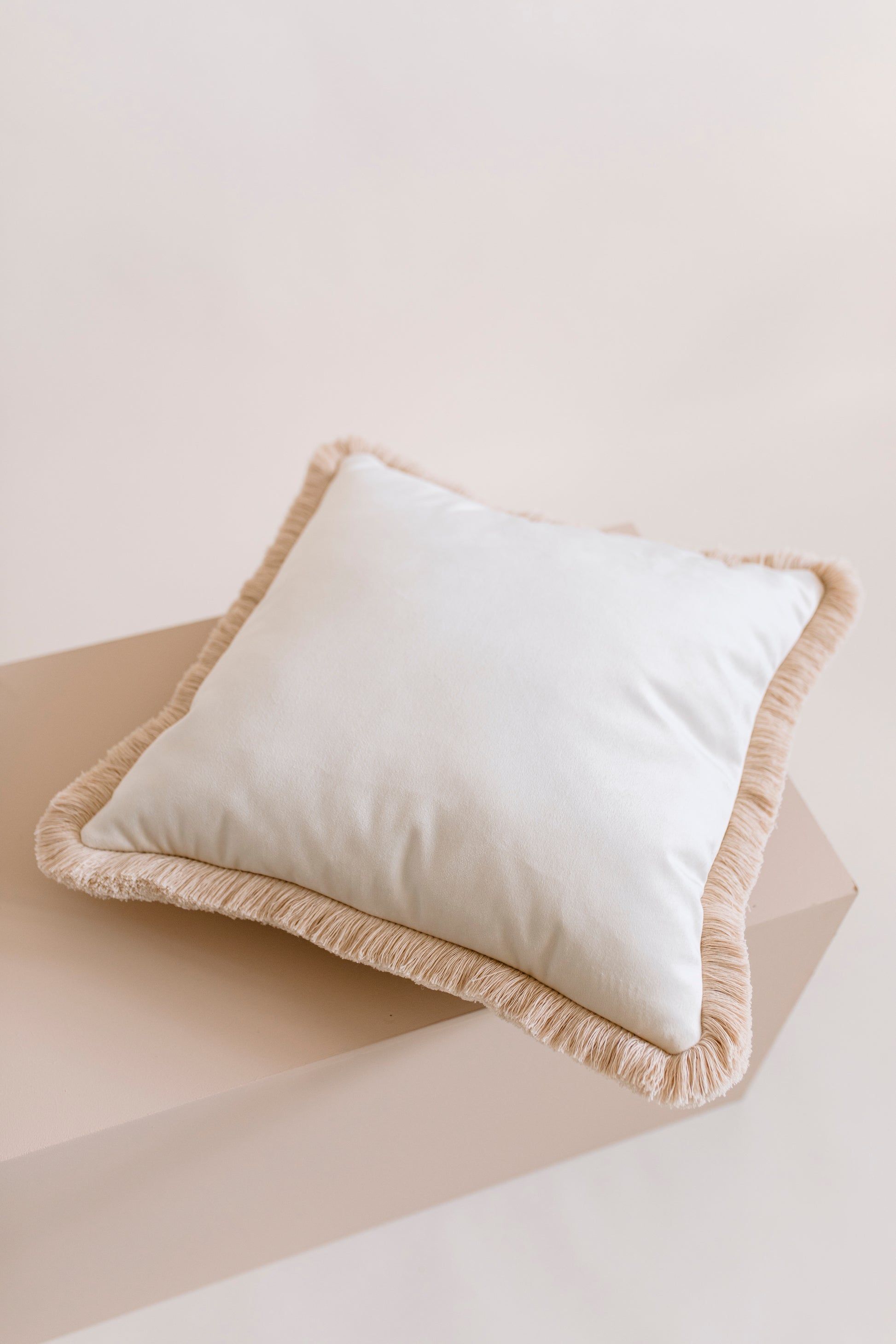 ecru square velvet cushion lying on a pastel floor