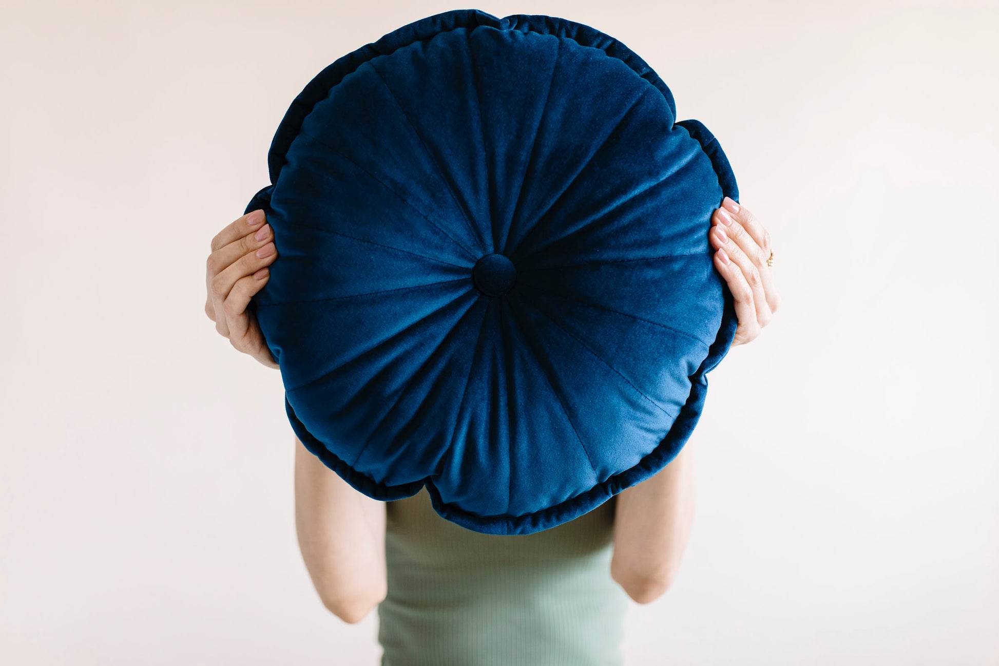 a close up on a girl holding round flower cushion