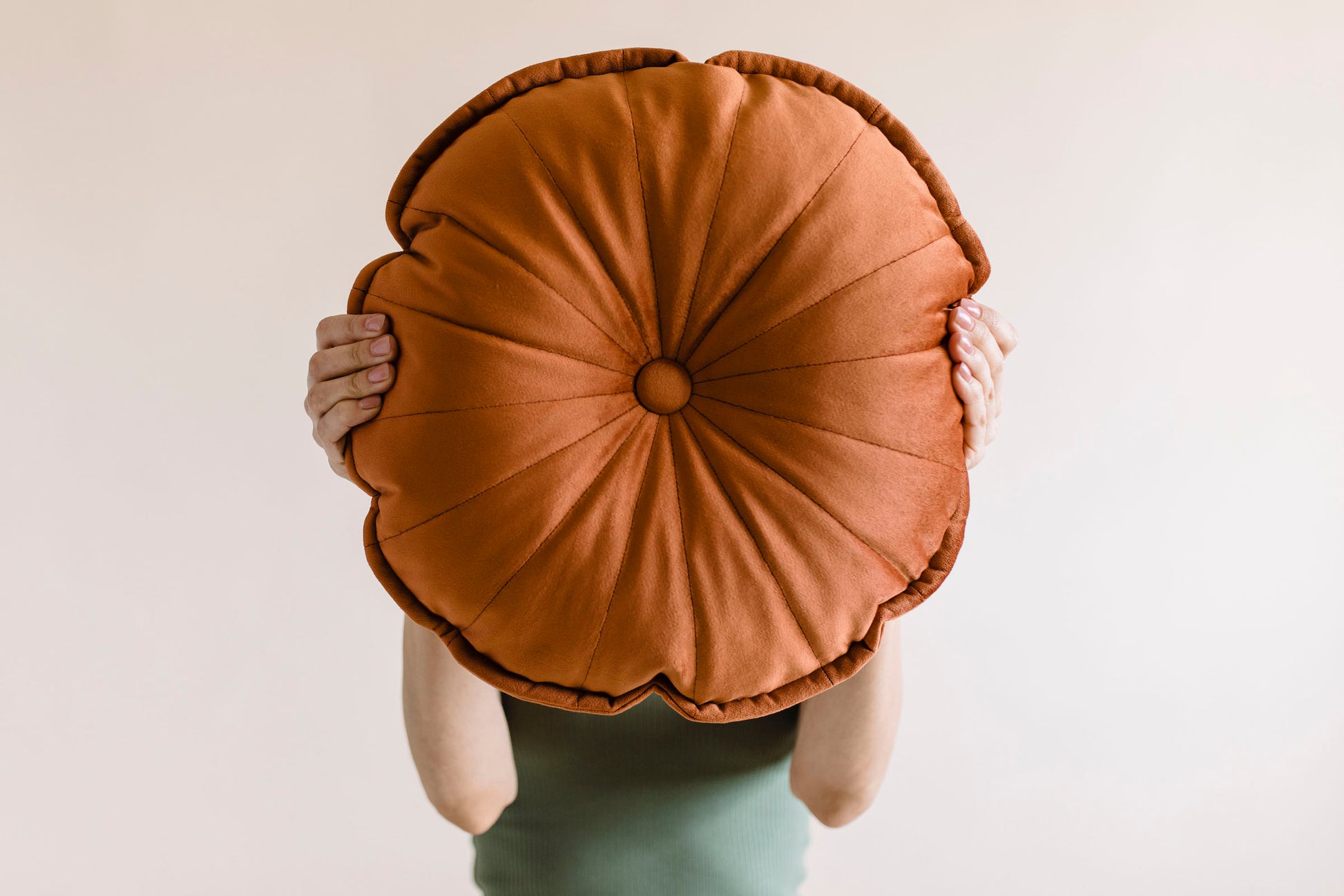 a girl holding round velvet cushion